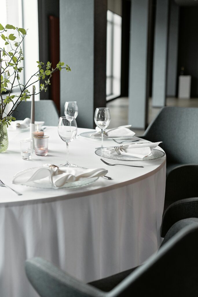 A beautifully set dining table with wine glasses and cutlery in a modern restaurant setting.