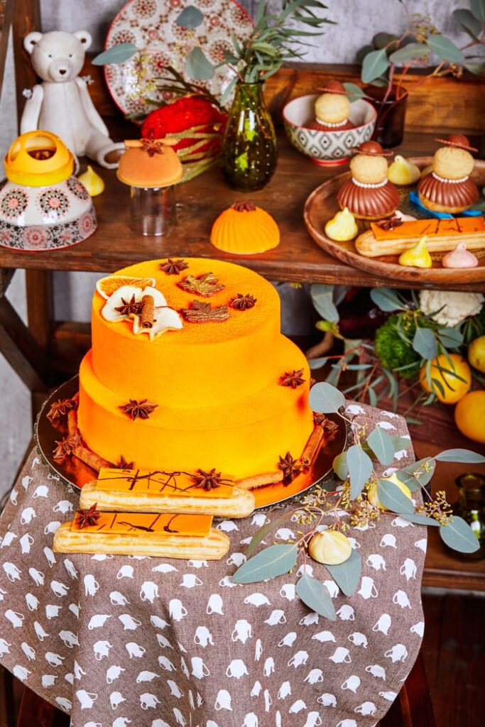 A beautifully decorated orange cake with star anise, perfect for celebrations.